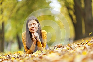 Girl laying on autumn leafs