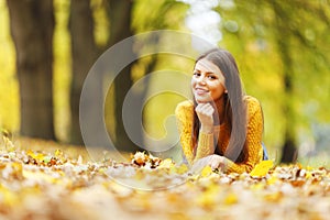 Girl laying on autumn leafs