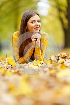 Girl laying on autumn leafs