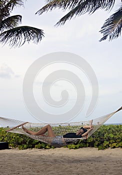 Girl laying at the beach in a hammock