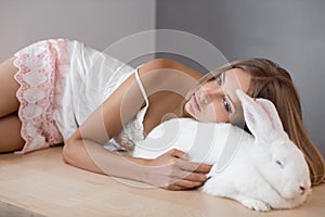 Girl laying with his pet big rabbit