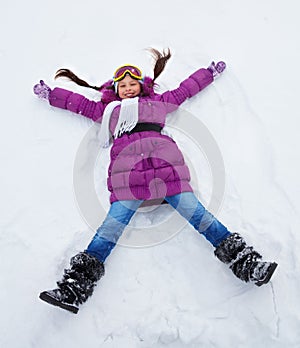 Girl laying in star shape in snow