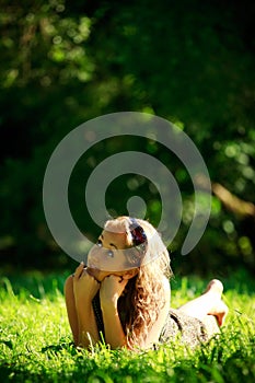 Girl laying on sunny meadow