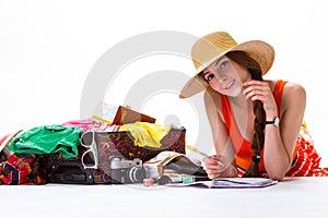 Girl lays near overfilled suitcase.