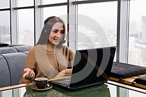 Girl leads some online broadcast from the coffee shop and talks with listeners