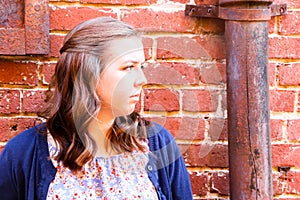 Girl Leaning Against Red Brick Wall