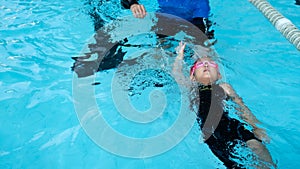 A girl learn how to swim in swimming class