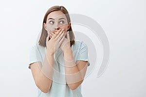 Girl learn shocking secret trying keep it. Portrait of shocked and astonished concerned speechless woman covering mouth