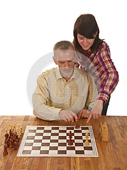 A girl is learning her father how to checkmate