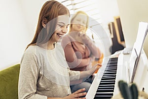 Girl learning play piano with teacher