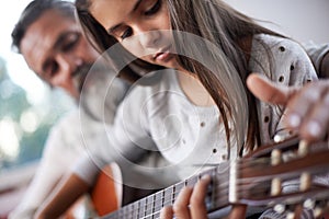 Girl learning to play guitar, grandfather teaching child with music education and help with creativity. Musician, art