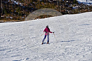 Girl enjoying and raises the hand during skiing on snow