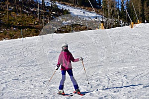 Girl enjoying and raises the hand during skiing on snow