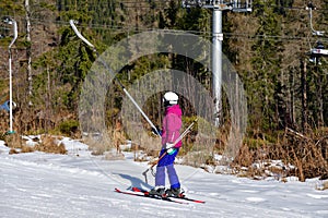 The girl is holding a cable on a ski lift in snowy  winter