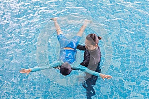 Girl learning to swim with coach