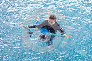 Girl learning to swim with coach