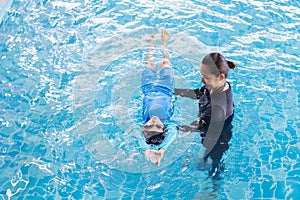 Girl learning to swim with coach