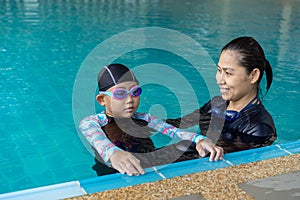 Girl learning to swim with coach