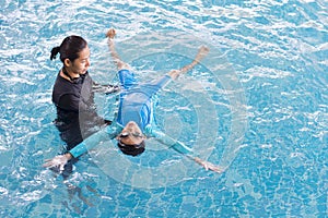 Girl learning to swim with coach