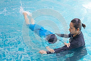 Girl learning to swim with coach