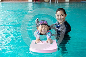 Girl learning to swim with coach at the leisure