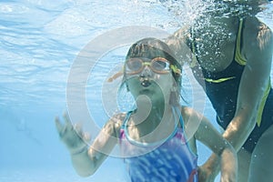 Girl learning to swim with mom