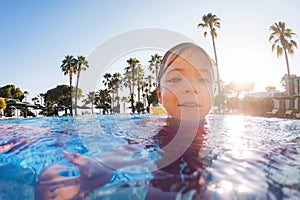 Girl learning to swim in the pool during summer vacation. Beach resort vacation by sea. Winter or summer seaside resort