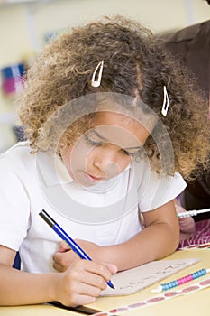 Girl learning to write numbers in primary class