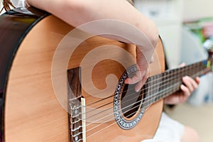 Girl learns to play guitar during a music lesson on the instrument