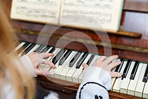 The girl learns to play the piano at the lessons at the music school.