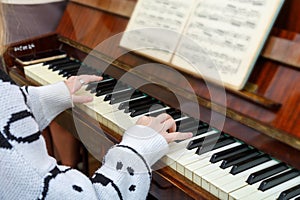 The girl learns to play the piano at the lessons at the music school.