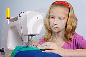 Girl learns to sew on an electric sewing machine