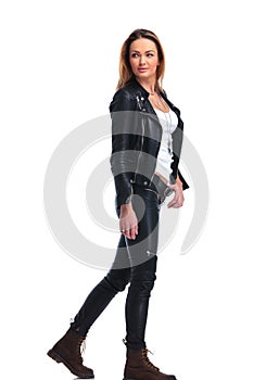 Girl in leather jacket pose walking in studio background while l photo