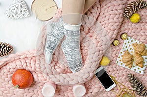 Girl legs in a socks on Merino wool blanket, trendy concept. Close-up flatly