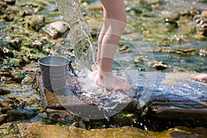 Girl legs under pure water stream