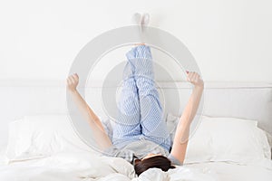 Girl with legs up lying on bed in bedroom