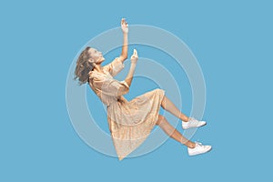 girl levitating, flying in dream with hands up, reaching for something high.