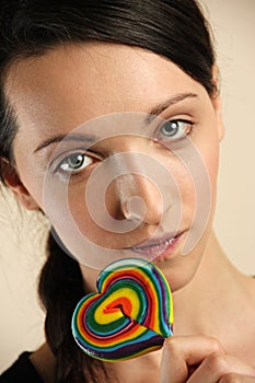 Girl licking a coloful lollipop.