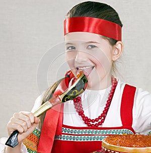 Girl licks a spoon with red caviar