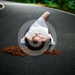 Girl lie on a road - hitchhiking