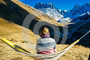 The girl lies on a hammock in the background of the mountains. Caucasus Mountains in Georgia
