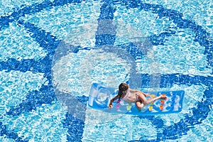 A girl lies on mattress in the pool photo