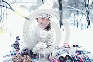 The girl lies on the snow in the winter forest or park. Concept - Christmas vacations and holidays.