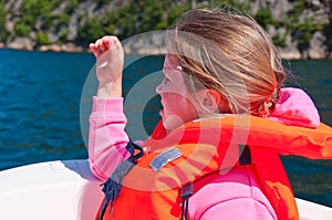 The girl in a lifejacket sitting in a boat