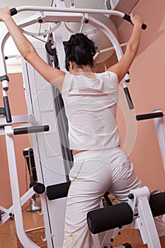 Girl lifting weight on gym apparatus