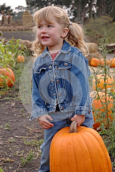 Girl lifts pumpkin