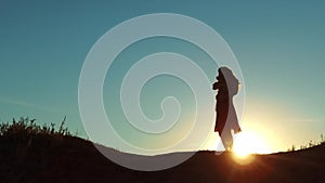 Girl lifts a small dog at sunset silhouette. woman playing with a dog on nature. silute sunlight. friendship man and pet