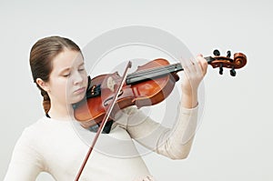 A girl in light dress with the closed eyes playing the violin over white background