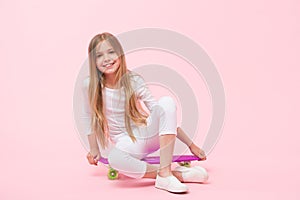 Girl likes to ride skateboard. Active lifestyle. Girl having fun with penny board pink background. Kid adorable child