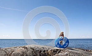 Girl with lilo on rocky beach